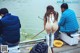 A group of people sitting on a dock fishing.