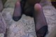 A close up of a person's feet in black stockings.