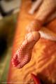 A close up of a woman's foot in a red fishnet stockings.