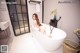 A woman sitting in a bathtub in a bathroom.