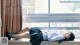 A woman laying on a window sill in a school uniform.