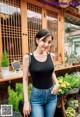 A woman standing in front of a flower shop.