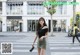 A woman walking across a crosswalk in front of a building.