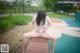 A woman sitting on a wooden bench in a park.