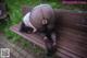 A woman in black pantyhose is laying on a wooden bench.