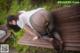 A woman in black pantyhose is sitting on a wooden bench.