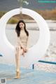 A woman sitting on top of a white circle on a dock.