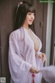 A woman in a white robe is posing for a picture.