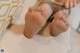 A close up of a person's bare feet on a couch.