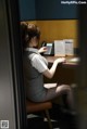 A woman sitting at a desk talking on a phone.