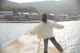 A woman standing on a pier near a body of water.