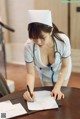 A woman in a nurse uniform writing on a piece of paper.