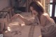 A woman sitting at a table with a bowl of fish.