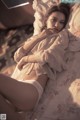 A woman laying on top of a bed next to a window.