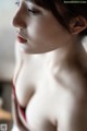 A woman in a red bra is looking away from the camera.