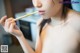 A naked woman holding a chopstick in her mouth.