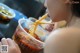 A woman eating a bowl of noodles with chopsticks.