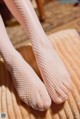 A close up of a woman's feet in fishnet stockings.