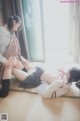 A couple of women sitting on top of a tatami mat.