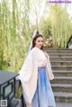 A woman in a blue and white dress standing on some steps.