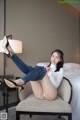 A woman sitting on a chair in a hotel room.