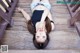 A woman laying on the ground with her hands on her face.